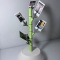bamboo shoot polaroid holder with pictures in the offshoots in a white vase